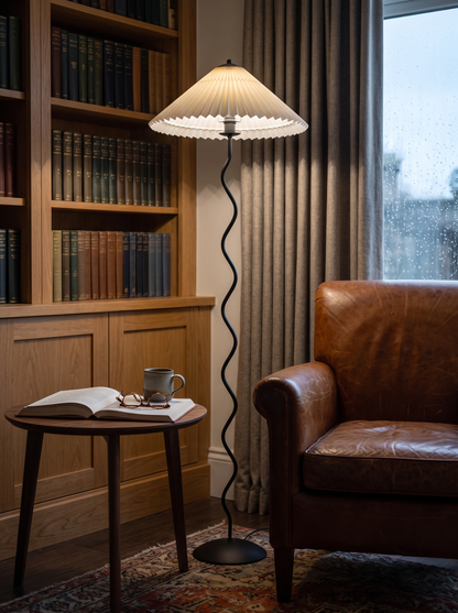 Dune floor lamp beside a leather reading armchair in a study