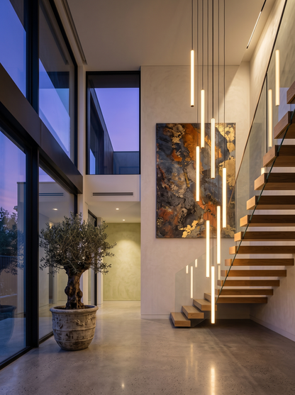 Filo pendants beside a floating staircase in a modern entryway