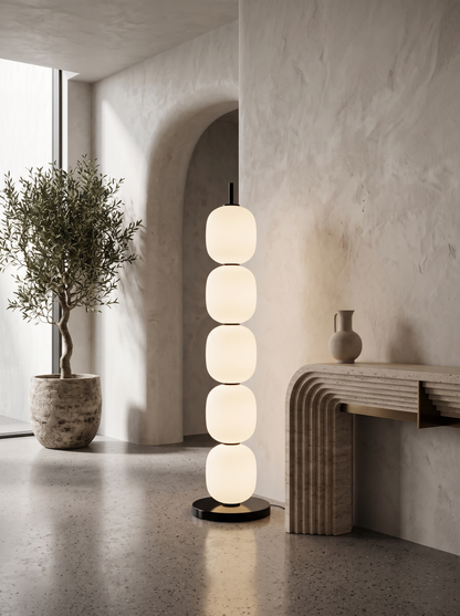 Sasso floor lamp in a sculptural entryway beside a travertine console